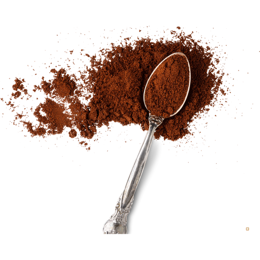 decaf ground coffee in a spoon on a white table top