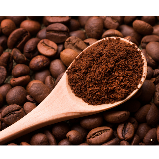 decaf ground coffee in a wooden scoop with roasted beans