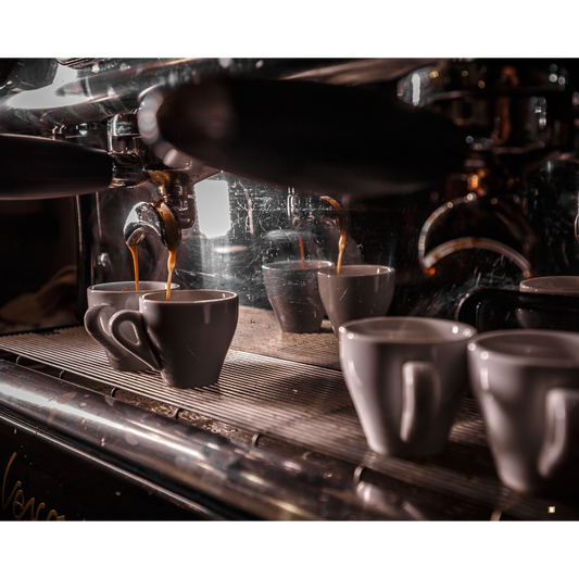 dripping coffee pod subscription machine into ceramic mugs