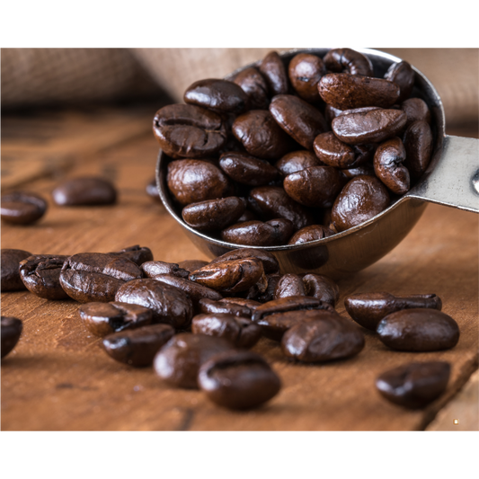 fresh roasted whole bean decaf coffee in a scoop on a wooden table