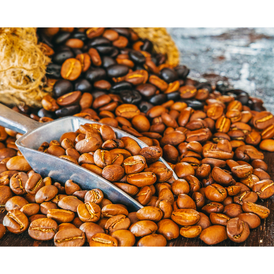 light roast coffee beans in a metal scoop with dark beans mixed in