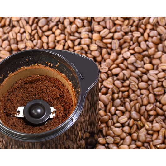 light roast coffee grounds in a grinder surrounded by coffee beans