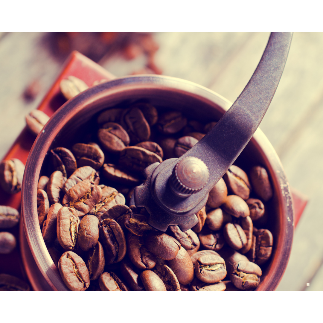 roasted whole bean decaf coffee in a hand grinder
