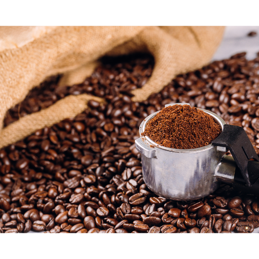 small batch coffee grounds in a scoop surrounded by coffee beans