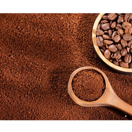 tanzanian peaberry coffee beans ground in a wooden scoop with whole beans