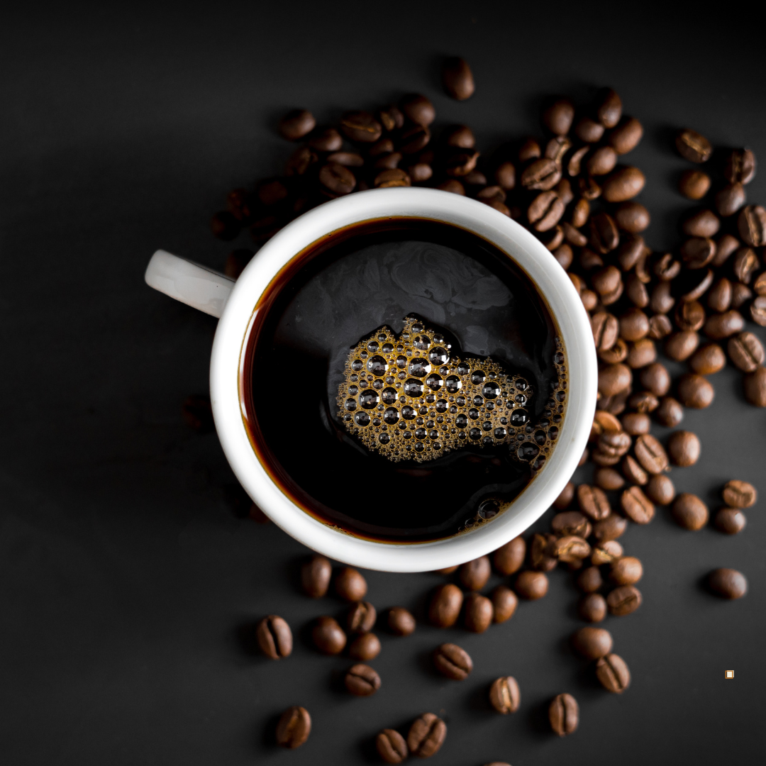 brewed cup of tanzanian peaberry coffee with beans on the table