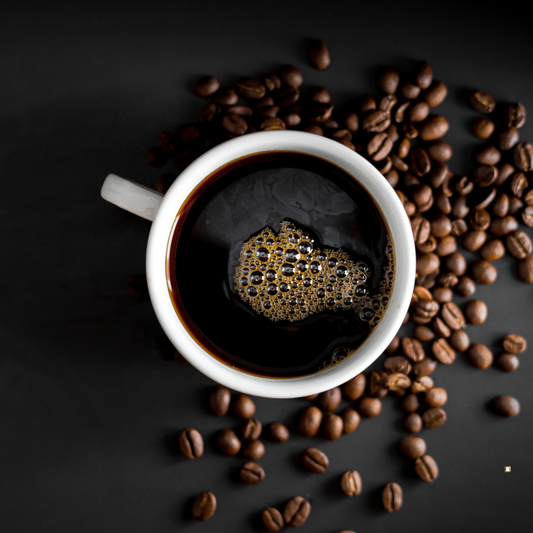 brewed cup of tanzanian peaberry coffee with beans on the table