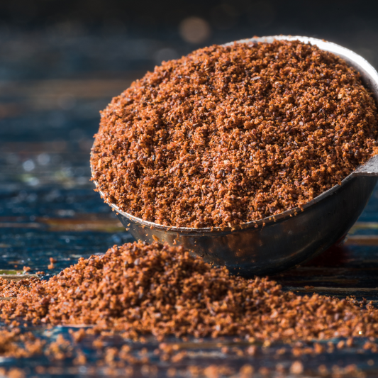 decaf ground coffee in a stainless steel scoop