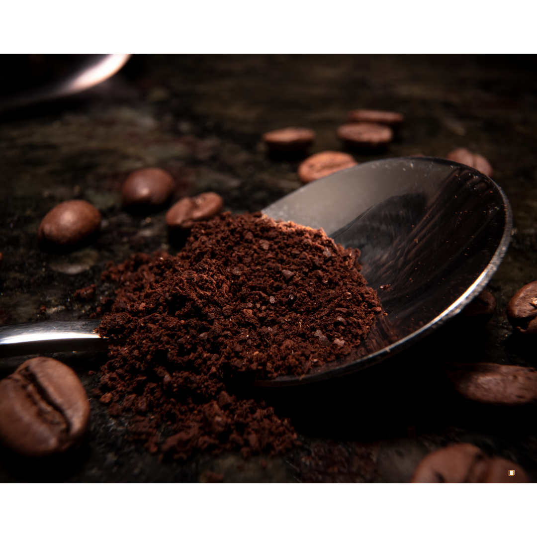 decaf ground coffee portion in a spoon on a table with coffee beans